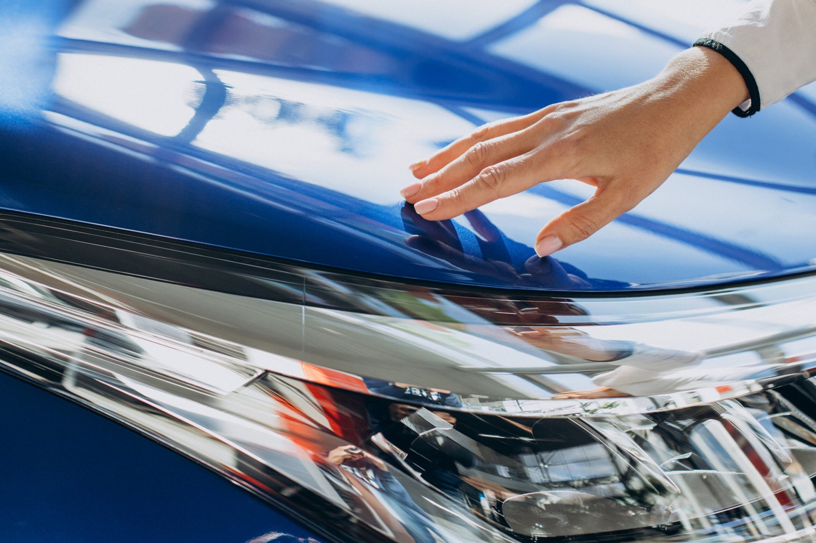 female-hands-touching-new-blue-car-close-up-1-scaled.jpg